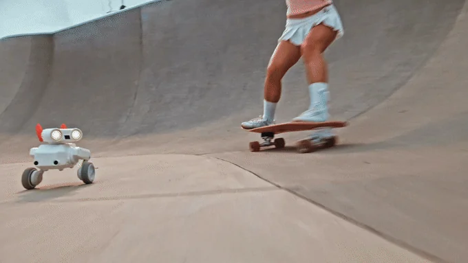 Beni filming beside a skateboarder in a concrete skatepark