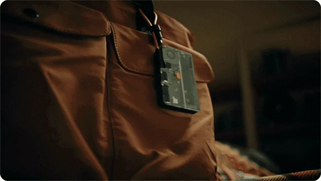 Transparent Disk Pro 2 hanging from a brown bag by its yellow lanyard cable