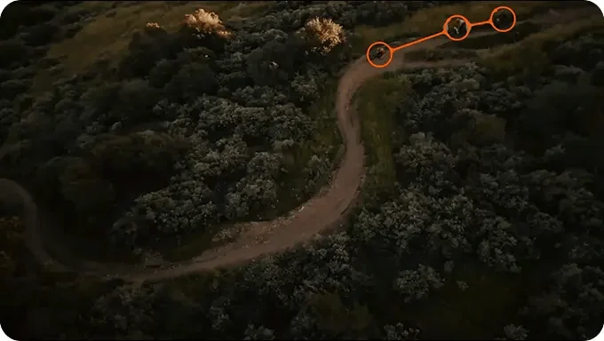 Aerial view of cyclists linked by an orange mesh communication line